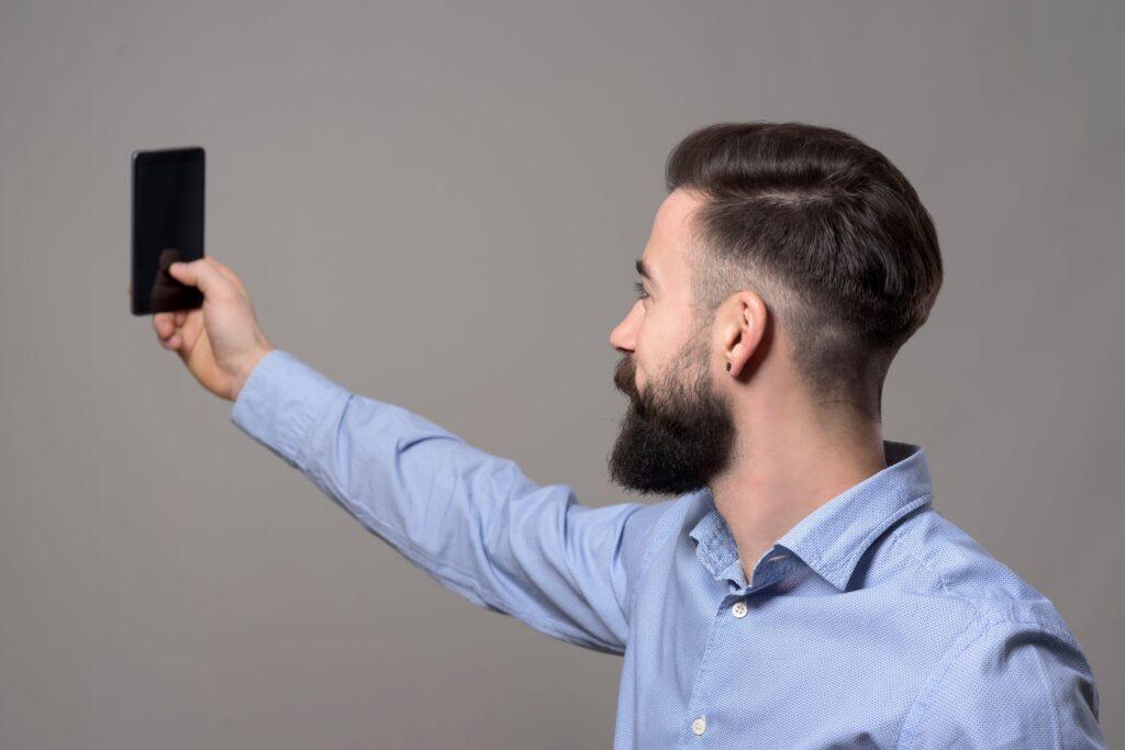 Man taking selfie with smartphone illustrating digital identity